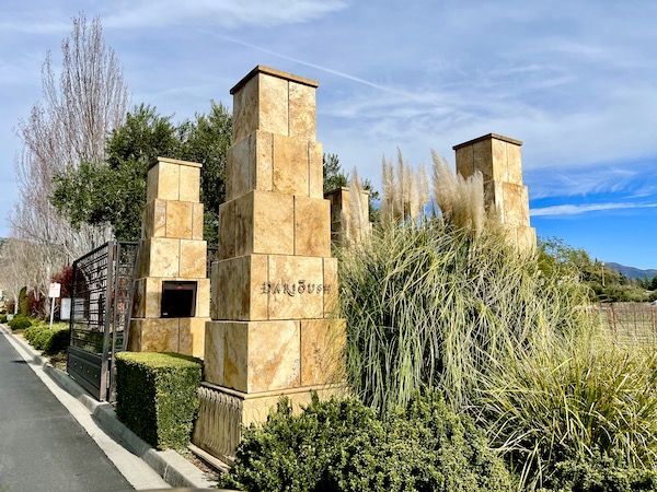 Beige stone pillars and greenery at the entrance to Darioush Winery, our first stop on our Napa Valley Winery Tour
