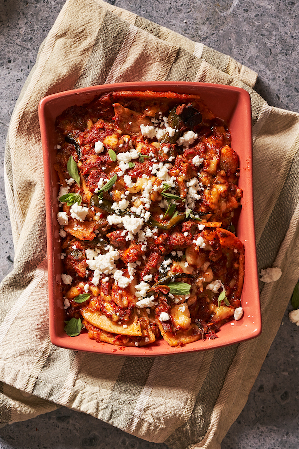 A terra cotta colored rectangular baking dish filled with tortilla casserole from The Tequila Diet by Chef Dave Martin