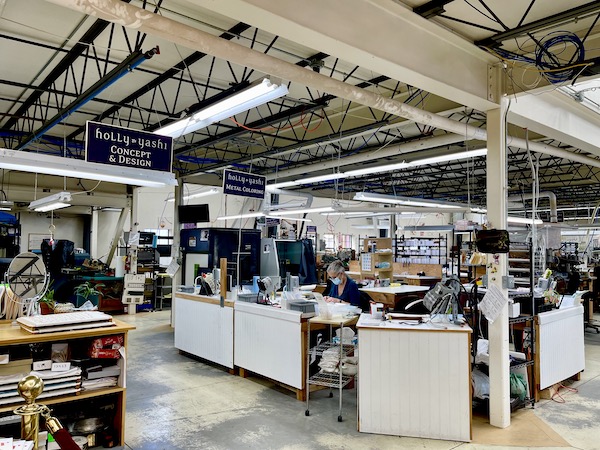 A warehouse jewelry studio with work tables and people making jewelry at Holly Yashi Store and Studio