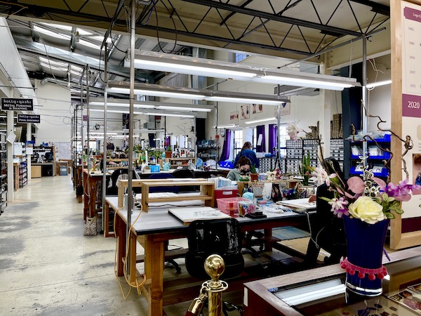 People working at jewelers benches at the Holly Yashi Store and Studio