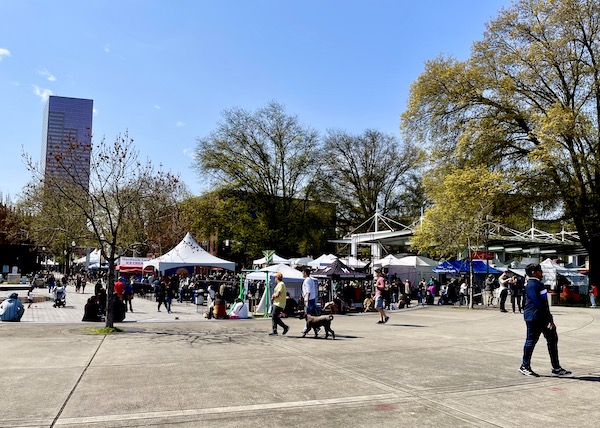 A park with art tents, people and trees