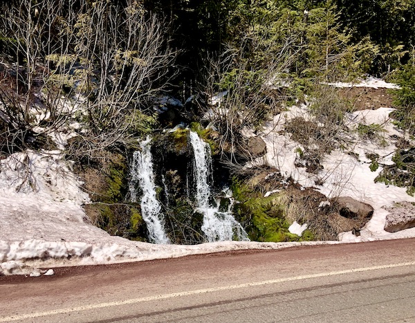 Snow and tree covered mountain with a short double waterfall at Mt. Hood Oregon