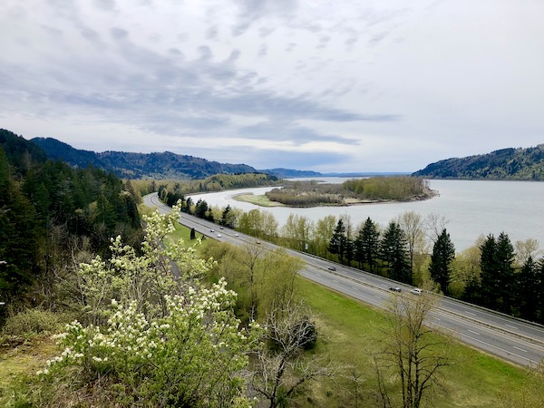 A wide river with islands, trees, mountains and clouds sky near Multnomah Falls Oregon