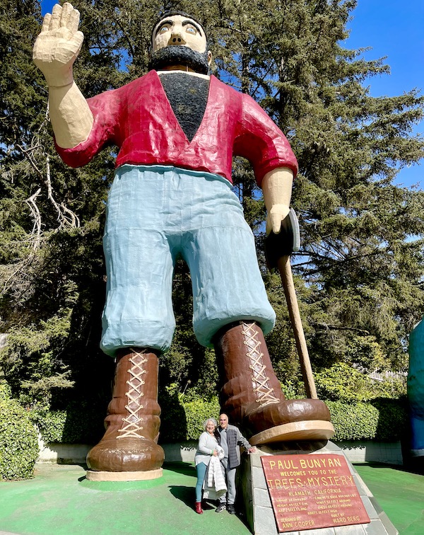 A sculpture of a logger with a man and woman standing at his feet at Trees of Mystery Klamath CA