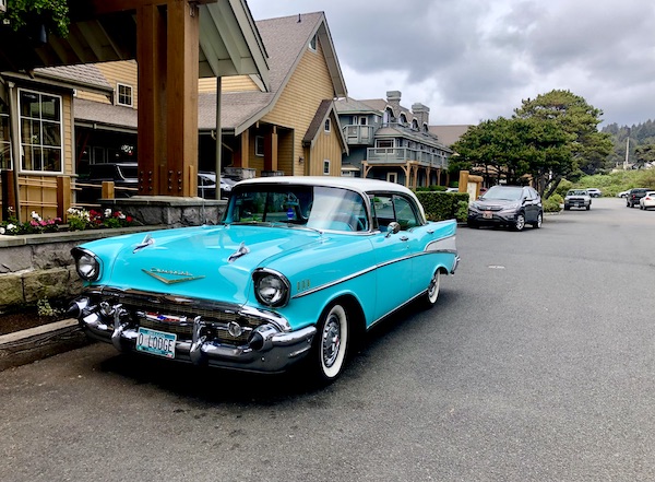 A turquoise vintage car with a white roof in Cannon Beach Oregon