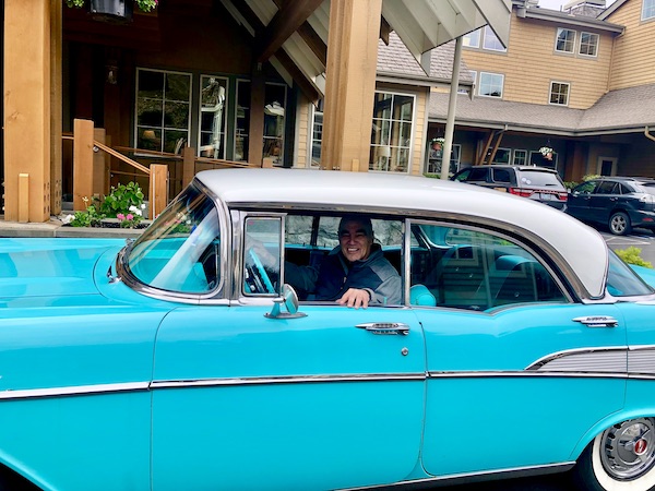 A man with a big grin sitting in the driver's seat.