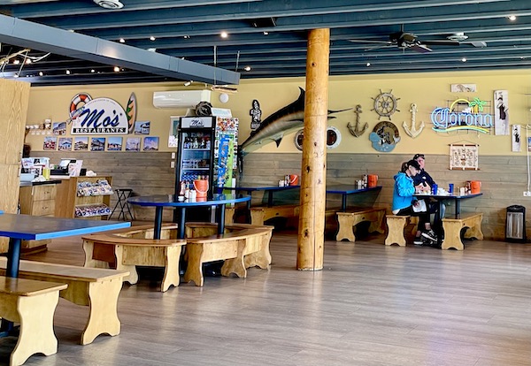 Interior of a restaurant with picnic tables and memorabilia on the walls in Cannon Beach Oregon