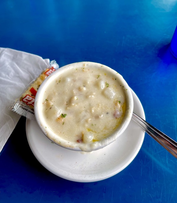 A blue table top with a bowl of creamy clam chowder at Cannon Beach Oregon