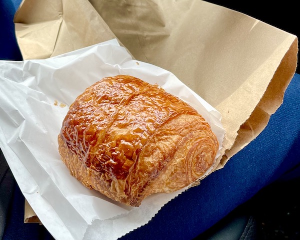 A pastry on deli paper and a brown paper bag in Seattle WA