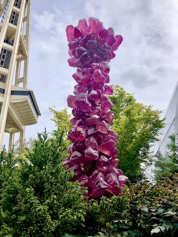 Tall glass tree made of chunks of amethyst glass at Chihuly Gardens Seattle WA
