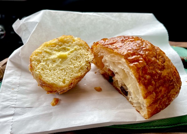 White paper topped with half a chocolate croissant and half a malasada in Seattle WA