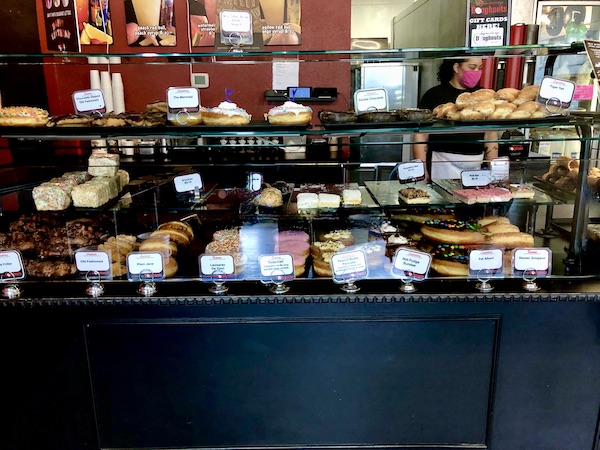 A glass pastry case filled with assorted donuts at Legendary Doughnuts Tacoma WA