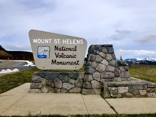A beige and stone sign welcoming you to Mount St. Helens Washington