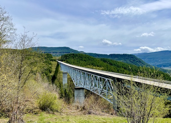 Long bridge over land with mountains in the distance en route to Mount St. Helens Washington