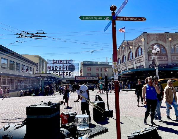 An outdoor area surrounded by buildings and live entertainment at Pike Place Market Seattle WA