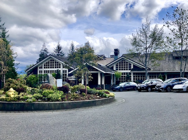 A brick lodge with trees and landscaping next to Snoqualmie Falls Washington