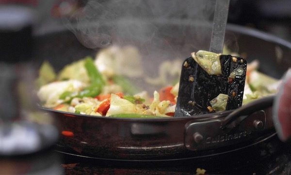 A sauté pan filled with vegetables cooking on a stove is one of the Top 3 Healthy Cooking Methods for Your Daily Life