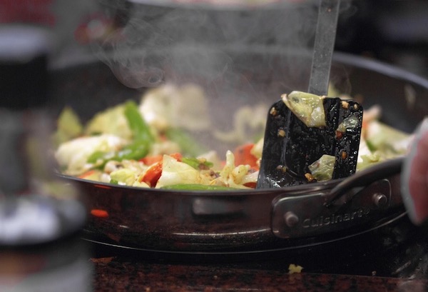 A sauté pan filled with vegetables cooking on a stove is one of the Top 3 Healthy Cooking Methods for Your Daily Life