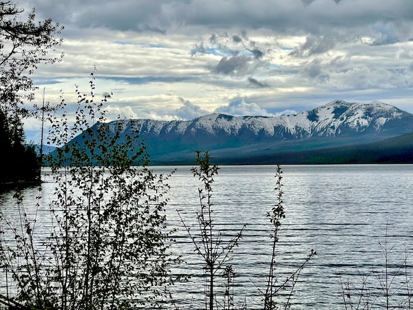 Snow capped mountain range at back of lake in Glacier National Park Montana