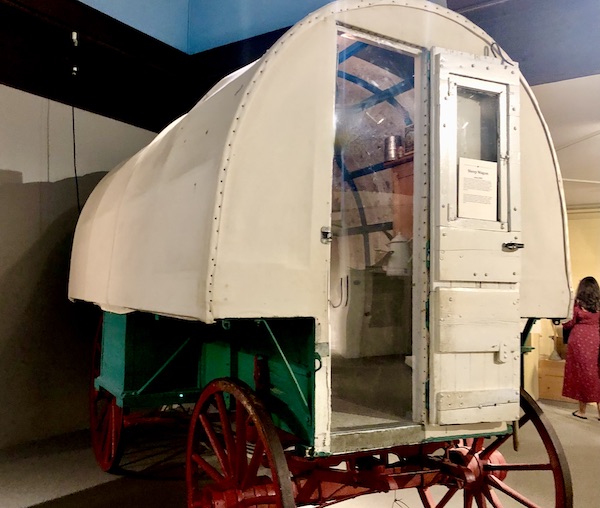 A covered wagon with stove inside on display at the Museum of the Rockies