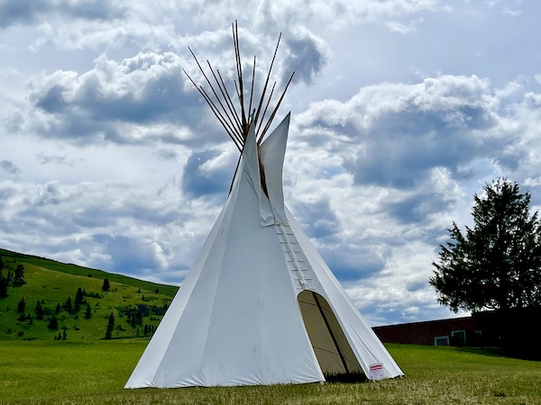 A white tipi with a warning sign that snakes are inside at the National Bison Range Montana