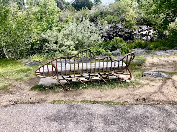 Park bench with back made of wood branches shaped into a fish in Idaho Falls