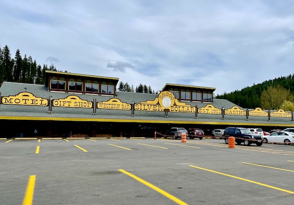 Long single story building with yellow signs for 50,000 Silver Dollar Casino and Inn en route from Spokane WA to Coram Montana