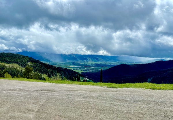 Gravel road, mountains and clouds rolling in on Teton Mountain Range Wyoming