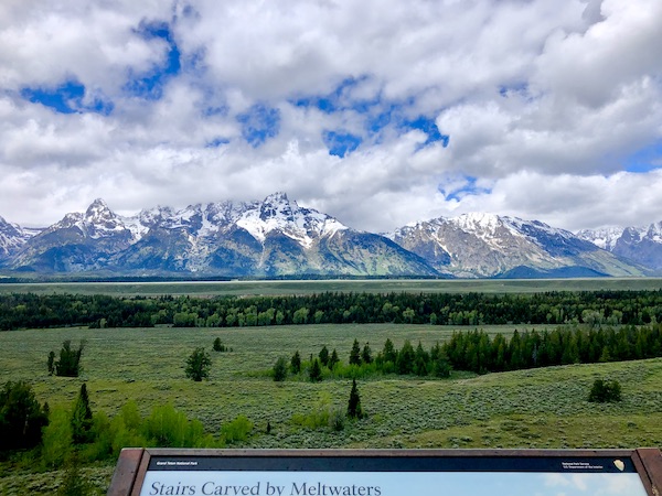 Lawn, trees and snow covered Teton Mountain Range Wyoming