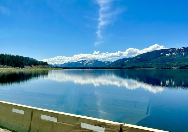 Clouds and mountains create a perfect mirror image in lake on our way to Visiting Spokane Washington