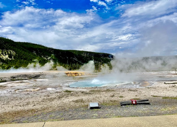 Spouter Geyser in front of mountains in Yellowstone National Park Wyoming