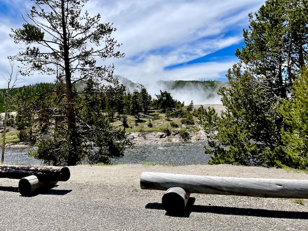 Steam rises from the ground near a river in Yellowstone National Park Wyoming