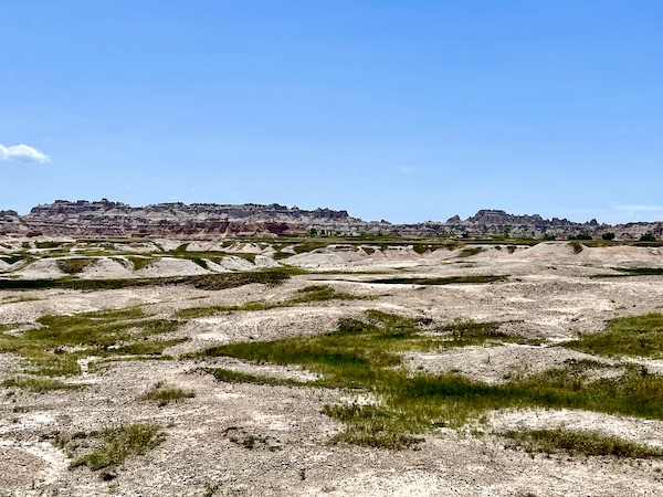 Sand like rock formations, grass and bushes at Badlands.