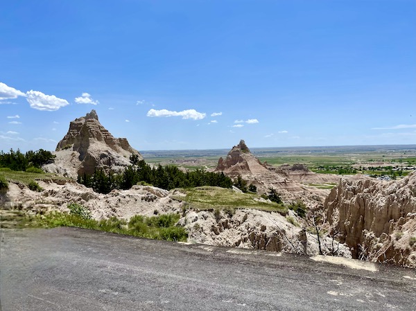 Pointed peaks, paved road and land for miles at Badlands National Park SD
