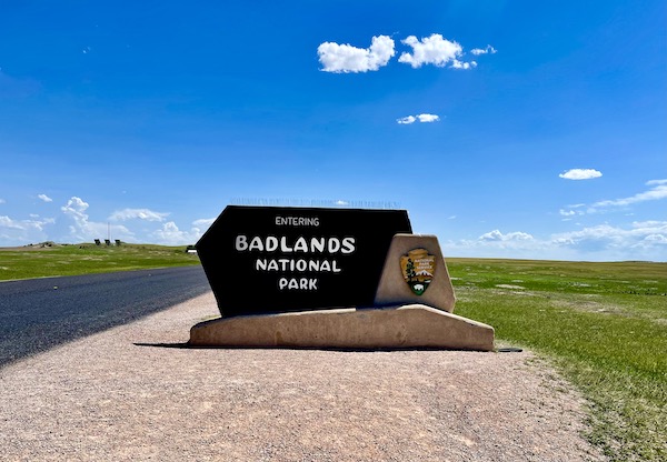 Stone and brown wood sign welcoming you to Badlands National Park SD