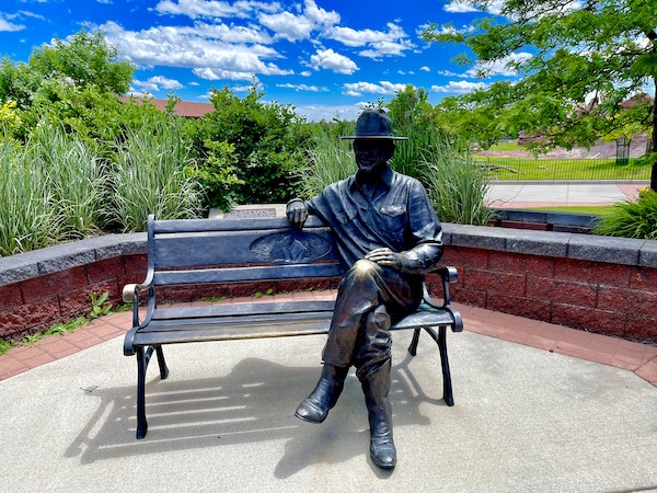 A park bench with a sculpture of the founder of Bear Country USA in South Dakota