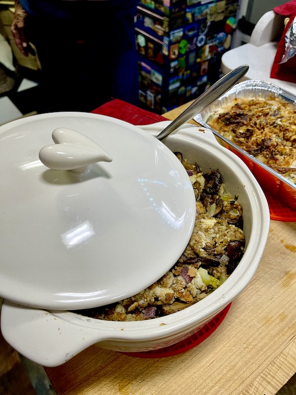 White casserole dish with heart handle on lid, filled with stuffing for a Happy Thanksgiving 2022!