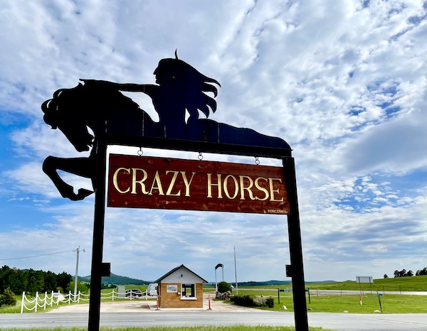 Metal sign of a native American on a horse with the words Crazy Horse