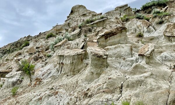 Mountain with cool rock formations and green plants.