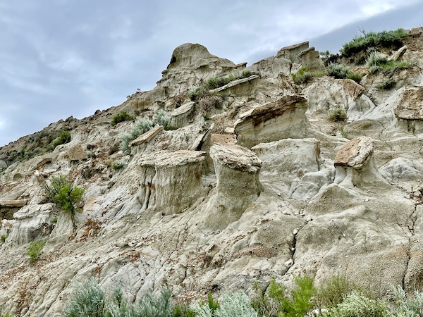Mountain with cool rock formations and green plants.