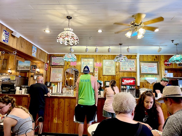 People at a counter ordering ice cream and milkshakes at Wall Drugs