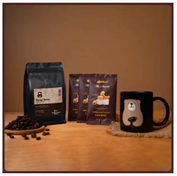 Black packets of candied nuts, coffee and coated nuts strewn on a red table, part of my 2022 Holiday Gift Guide