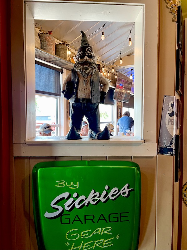 Gnome-like figure of a biker in an opening at Sickies Garage in Fargo