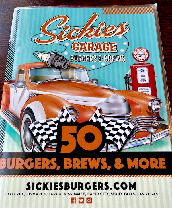 Turquoise and red poster of a truck inside Sickies Garage in Fargo