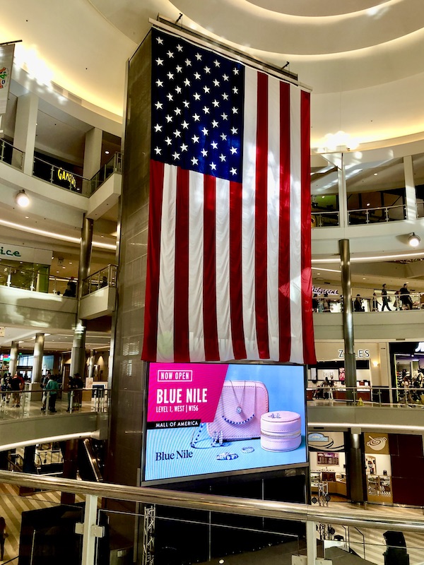 A large American flag hanging from the ceiling of Mall of America Bloomington MN