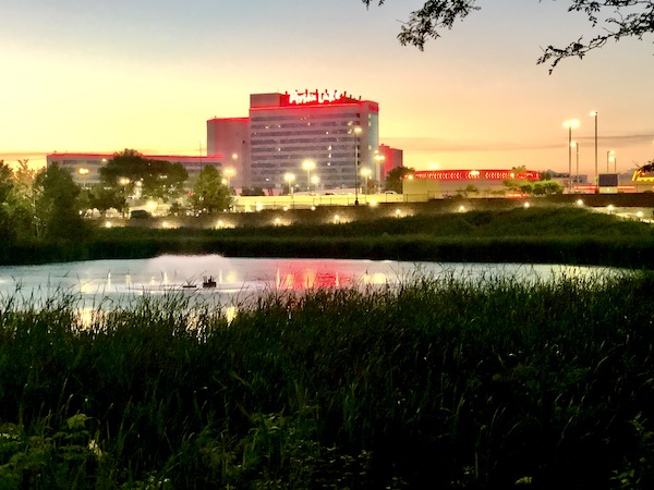 Mystic Lake Casino in distance with lake in front as sun is setting.