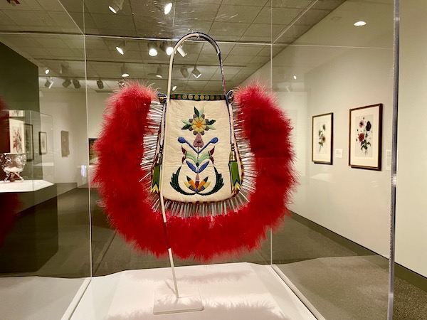 Red feather, Elk hide and beaded purse in a display case at the Minneapolis Institute of Art