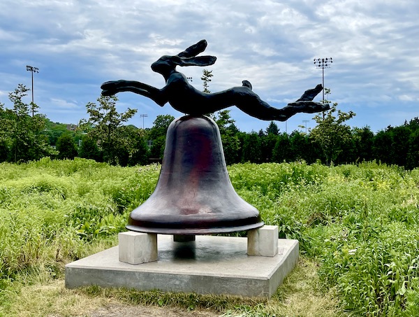 Bronze rabbit on top of a bronze bell sitting on white stone pillars at the Minneapolis Sculpture Garden Minnesota