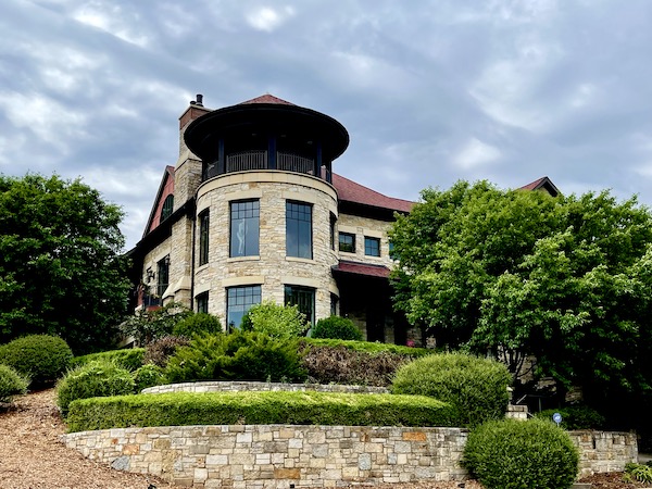 Beige stone house with rounded area of windows with garden in front in downtown Minneapolis MN