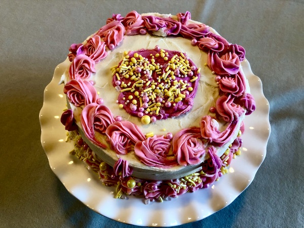 Beautiful white and hot pink iced cake on fluted white cake stand in Minneapolis MN